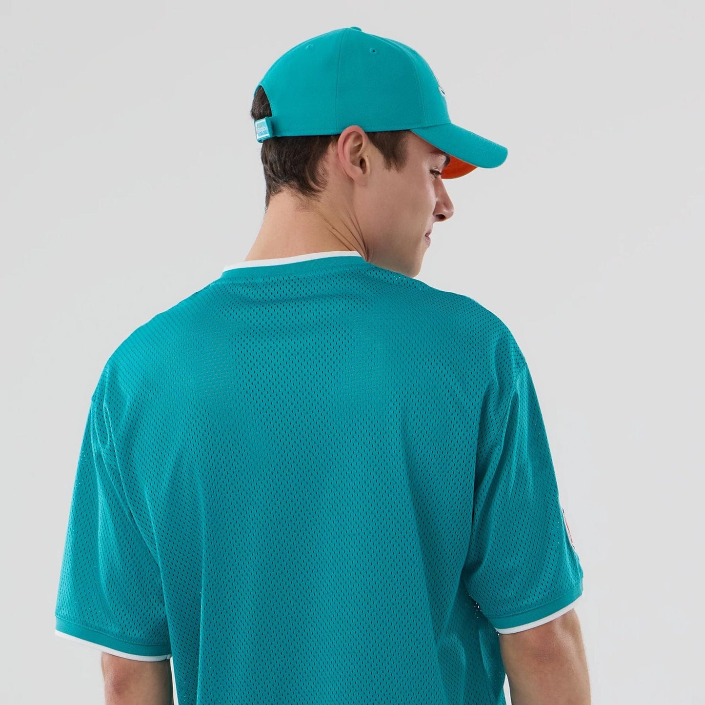 The model is wearing this NFL Mesh Miami Dolphins Oversized T-Shirt in turquoise. 7