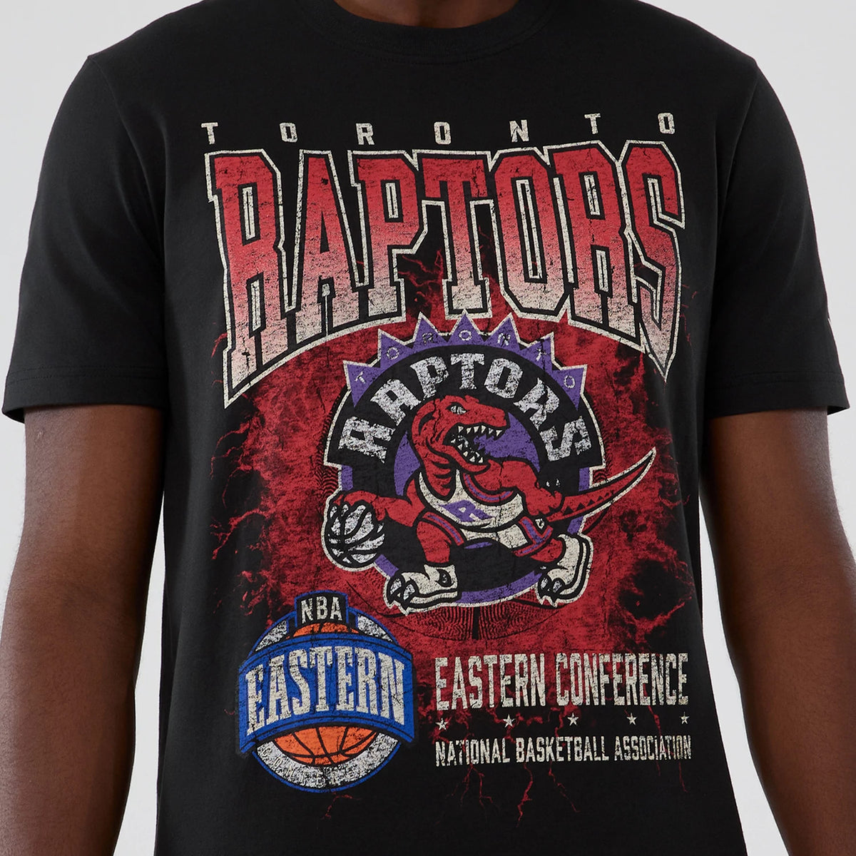 New Era Toronto Raptors NBA Hardwood Classic Black T-Shirt, front view showing a large distressed Raptors logo in red and purple with a raptor holding a basketball, NBA Eastern Conference lettering and a basketball graphic.