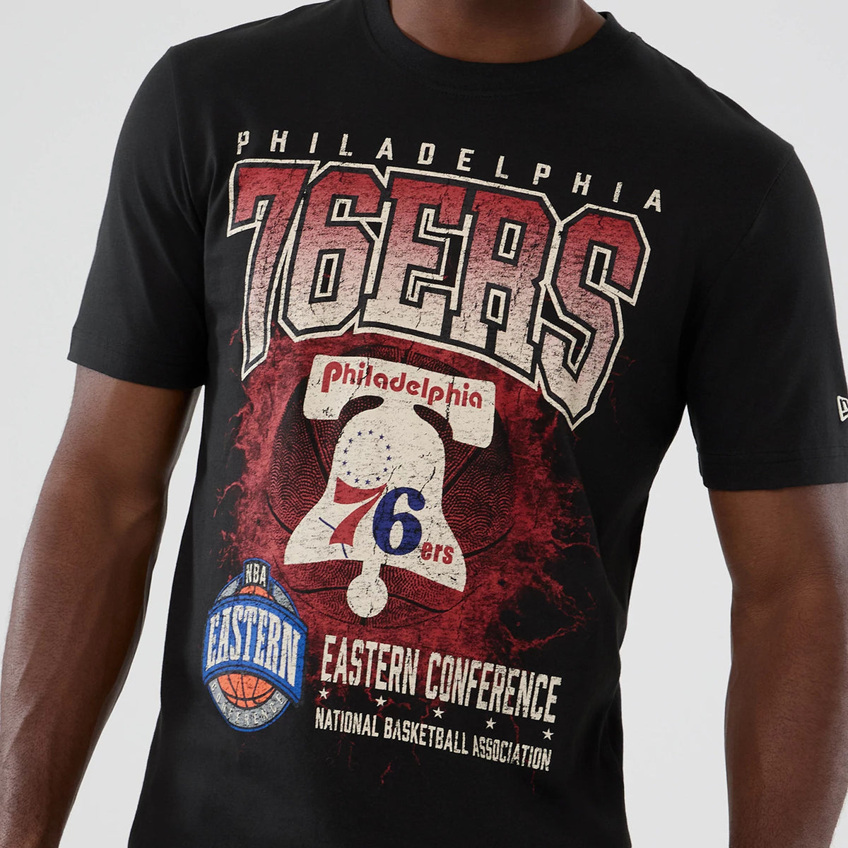 New Era Philadelphia 76ers NBA Hardwood Classic Black T-Shirt, front view showing large 76ers lettering and the Liberty Bell graphic on the chest, Eastern Conference and NBA logos below, with a small embroidered New Era logo on the sleeve.