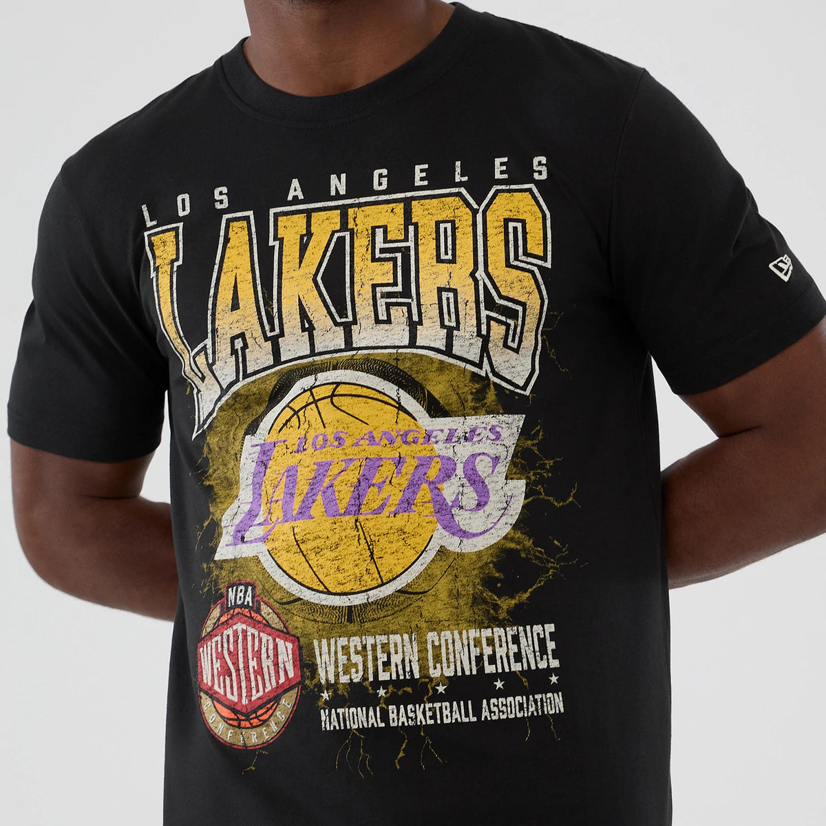New Era LA Lakers NBA Hardwood Classic Black T-Shirt, front view on a model highlighting a distressed graphic with Los Angeles Lakers text, a large yellow basketball, and NBA Western Conference logos.