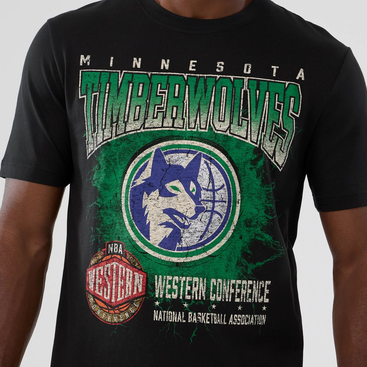 New Era Minnesota Timberwolves NBA Hardwood Classic Black T-Shirt, front view showing a distressed Timberwolves logo with green and blue graphics and vintage-style lettering, worn by a model.