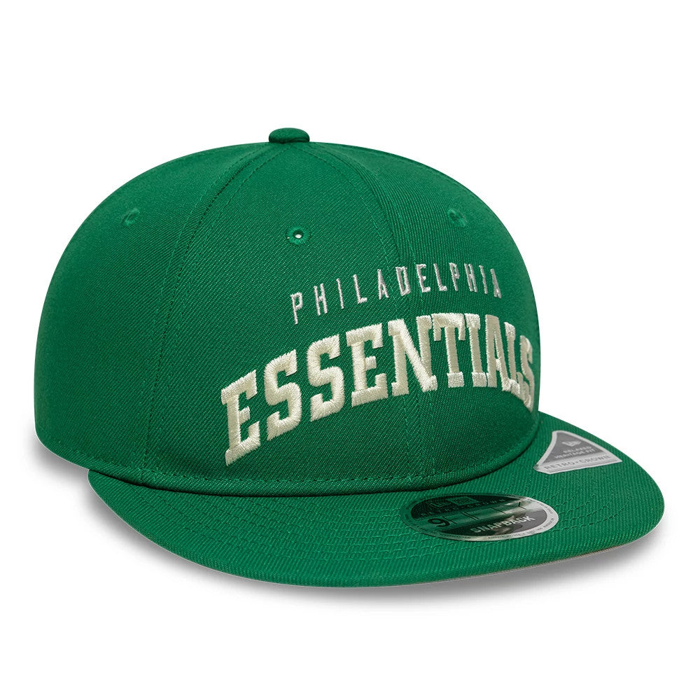Philadelphia Eagles Fear Of God x NFL Green Retro Crown New Era 9FIFTY Adjustable Cap, front view showing raised cream embroidery of Philadelphia Essentials text on the structured green crown with a 9FIFTY size sticker on the green flat visor.