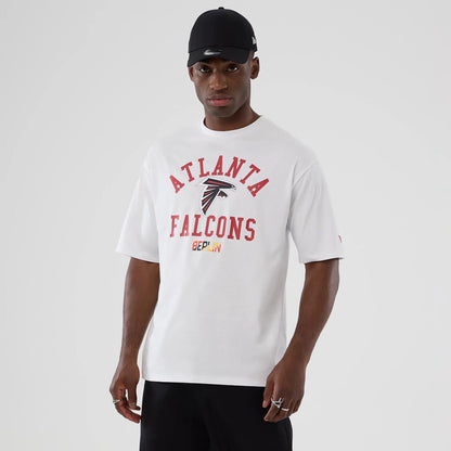 The Male model is wearing Atlanta Falcons NFL International Series Games 2025 White Oversized T-Shirt  1