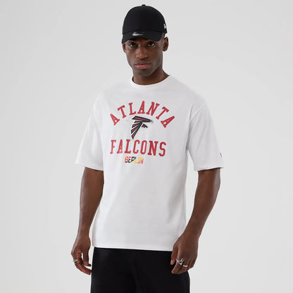 The Male model is wearing Atlanta Falcons NFL International Series Games 2025 White Oversized T-Shirt 1