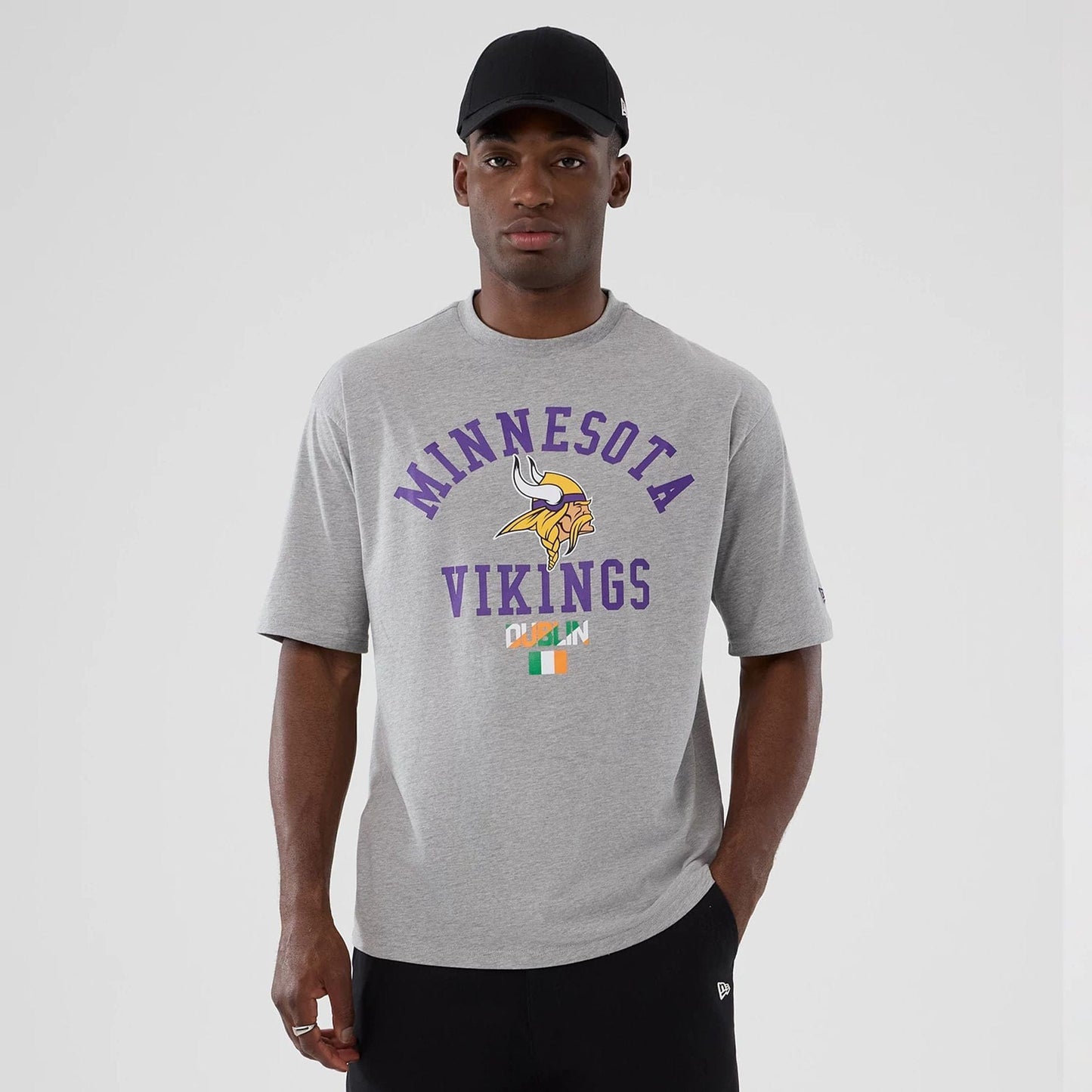 The Male model is wearing Minnesota Vikings NFL International Series Games 2025 Grey Oversized T-Shirt  1