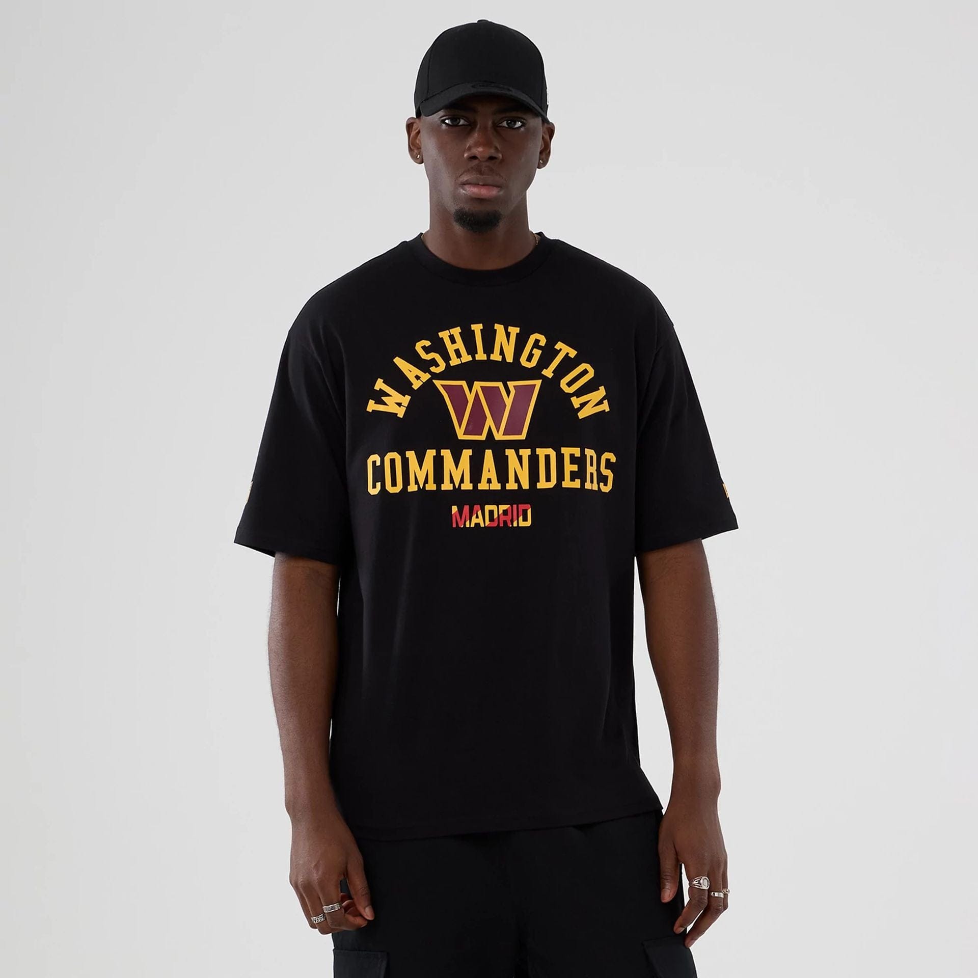 The Male model is wearing Washington Commanders NFL International Series Games 2025 Black Oversized T-Shirt  1
