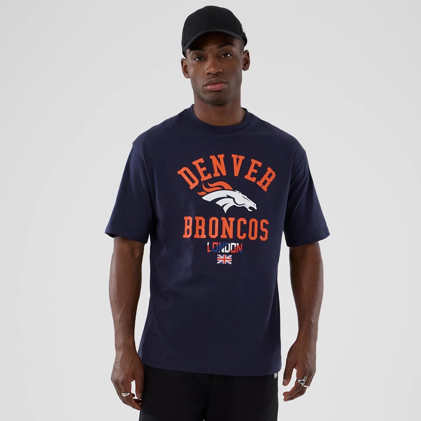 The Male model is wearing Denver Broncos NFL International Series Games 2025 Navy Oversized T-Shirt  1
