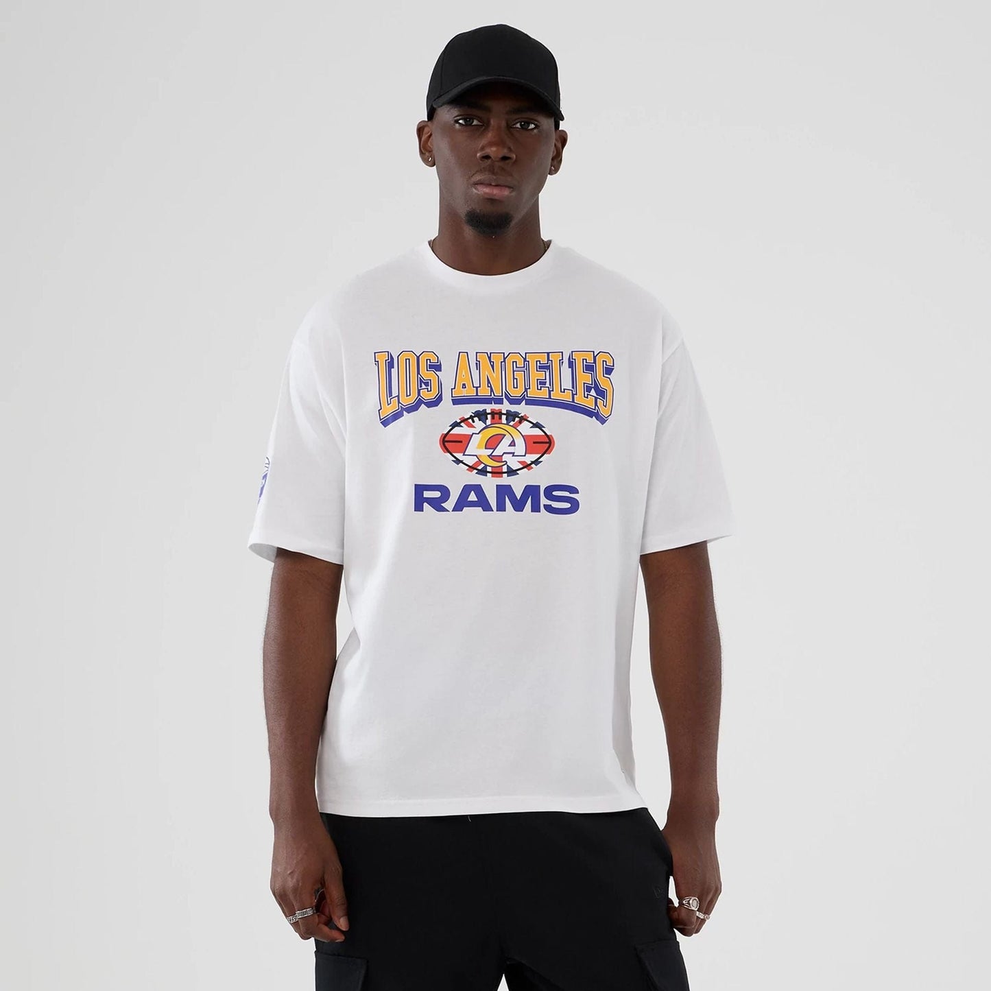 The Male model is wearing LA Rams NFL International Series Games 2025 White Oversized T-Shirt  1