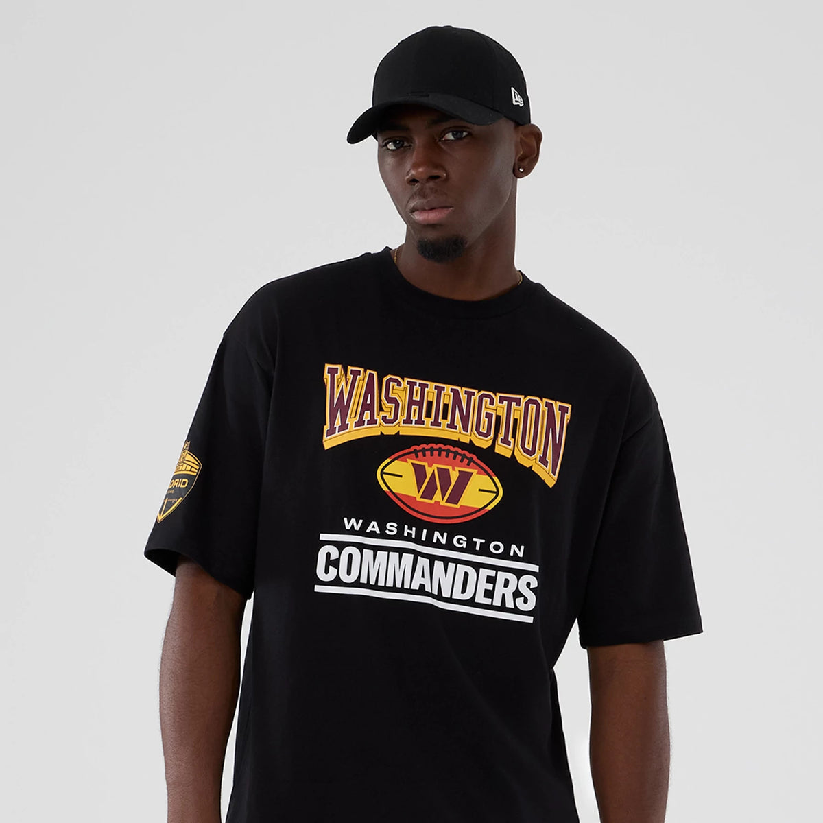 New Era Commanders NFL International Series Games Script 2025 Black Oversized T-Shirt, front view displaying the large Washington Commanders text and logo in yellow and white on the chest.