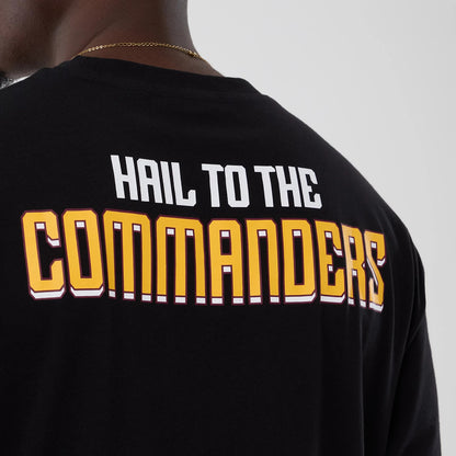 New Era Commanders NFL International Series Games Script 2025 Black Oversized T-Shirt, back view showing HAIL TO THE COMMANDERS printed in white and yellow across the upper back on a plain black fabric.