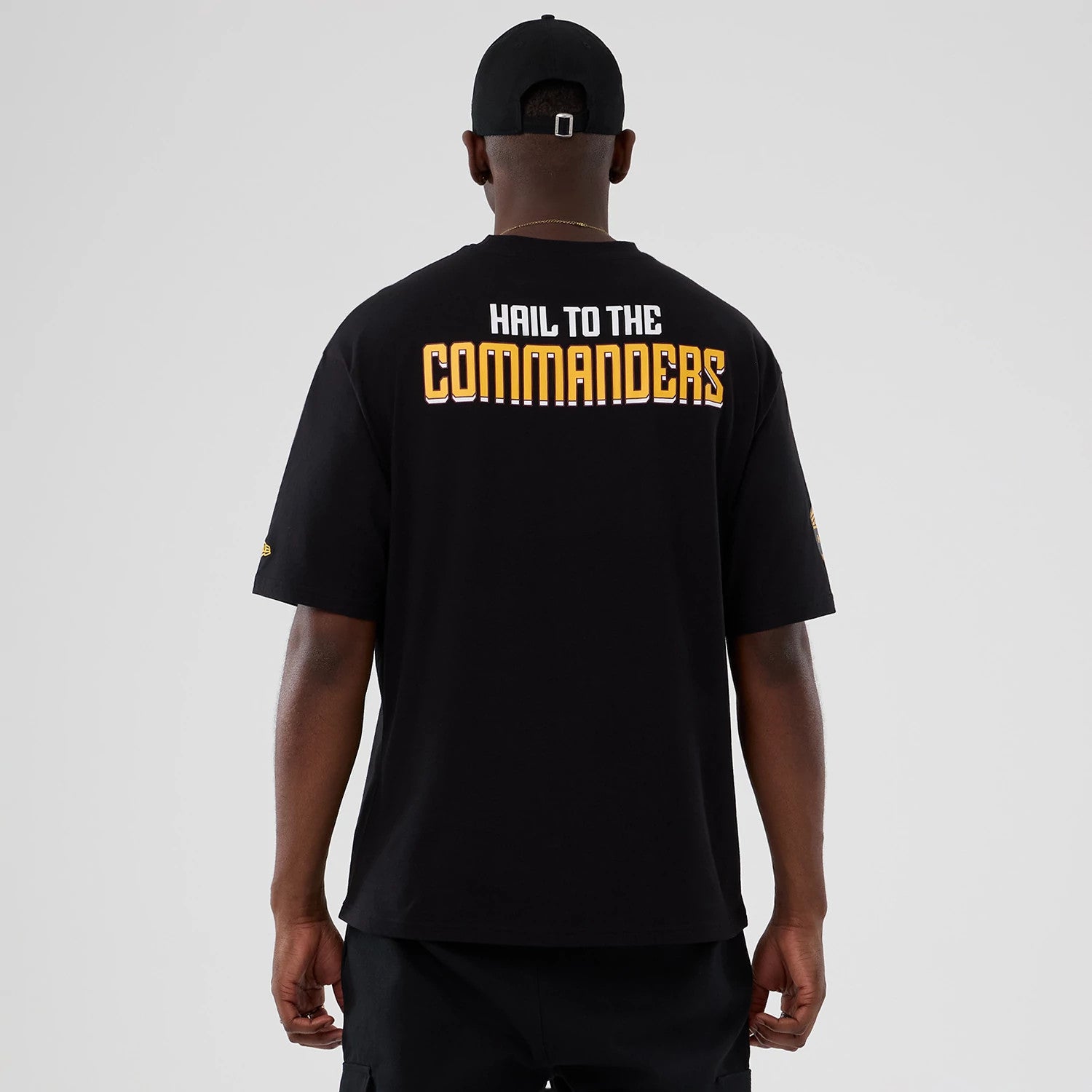 The Male model is wearing Washington Commanders Script NFL International Series Games 2025 Black Oversized T-Shirt 2
