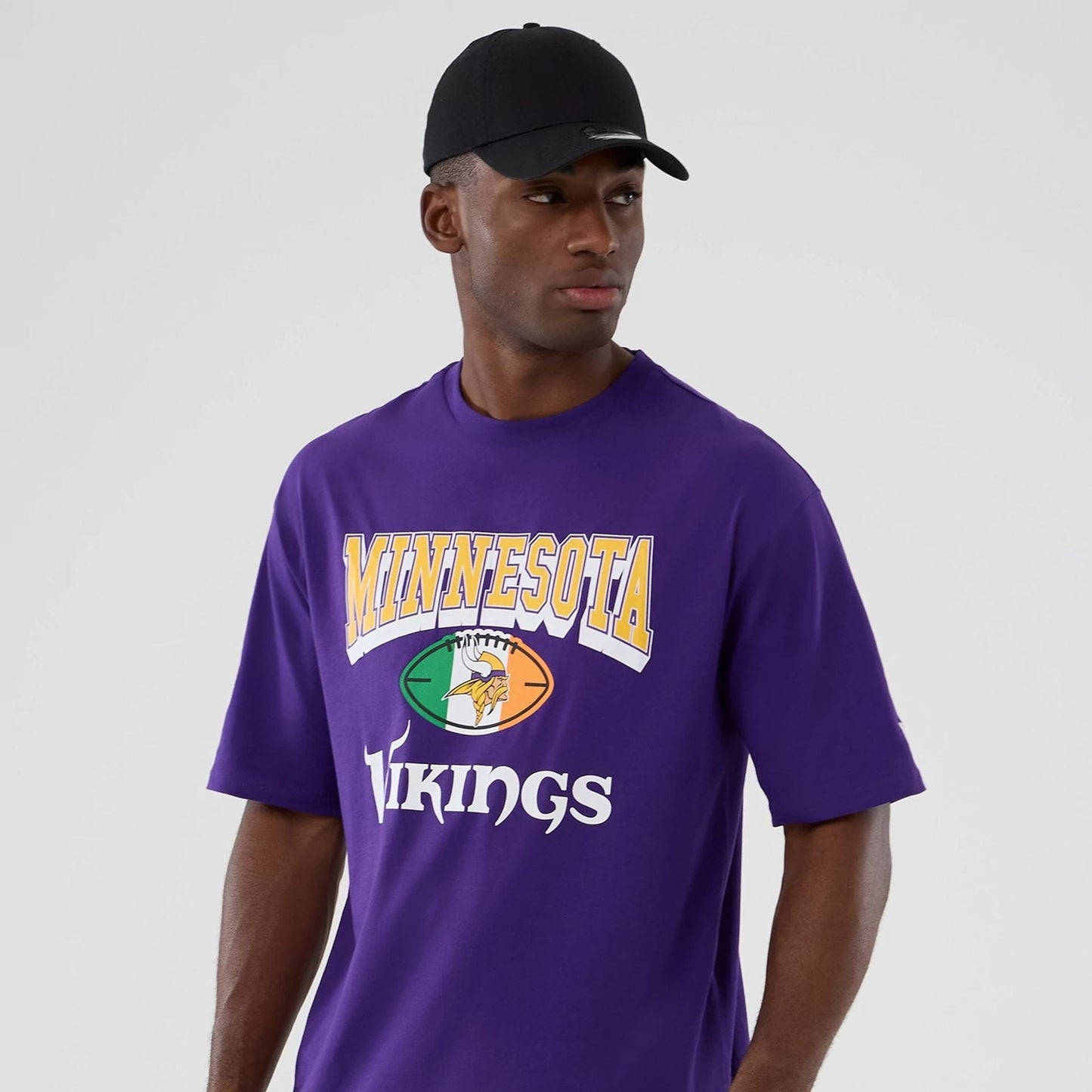 The Male model is wearing Minnesota Vikings NFL International Series Games 2025 Purple Oversized T-Shirt  3