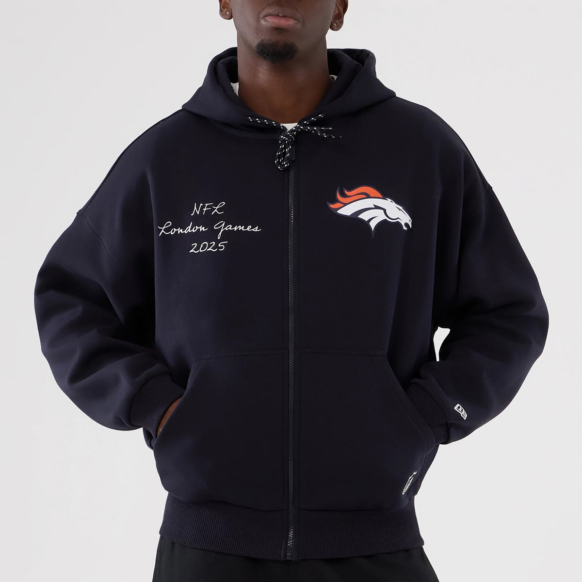 The Male model is wearing Denver Broncos NFL International Series Games 2025 Navy Premium Pullover Hoodie 5