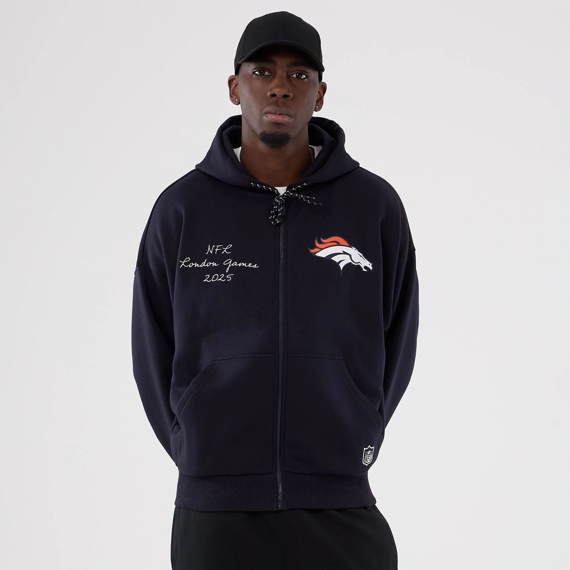 The Male model is wearing Denver Broncos NFL International Series Games 2025 Navy Premium Pullover Hoodie  1
