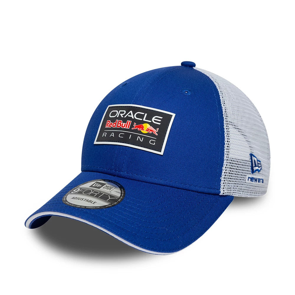 Red Bull Racing Dark Blue New Era 9FORTY Adjustable Cap, three-quarter view showing a black and white square logo patch embroidered on the front panel, a dark blue curved visor with a 9FORTY size sticker, and white mesh sides.