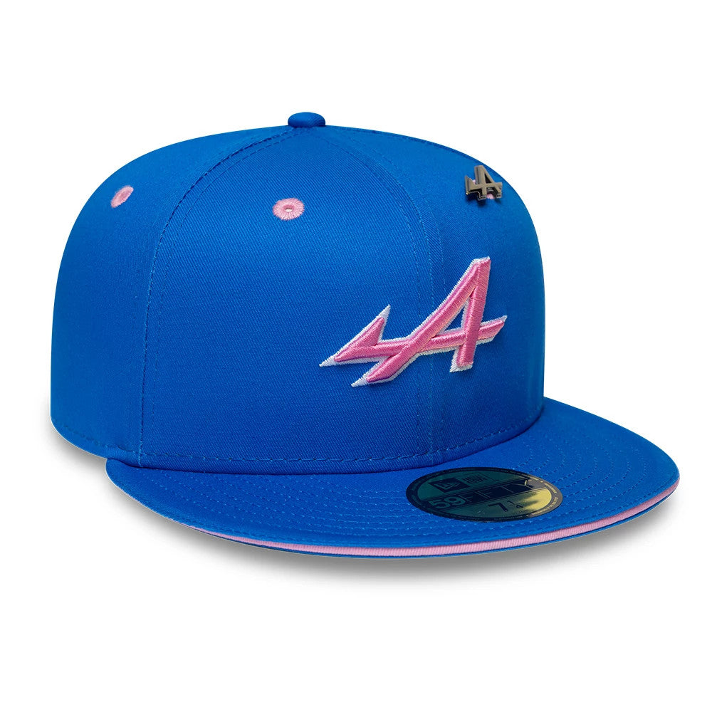 Alpine Racing Summer League Blue New Era 59FIFTY Fitted Cap, front view showing a pink embroidered A logo on the blue crown, with a blue visor edged in pink and a gold 59FIFTY size sticker on the visor.