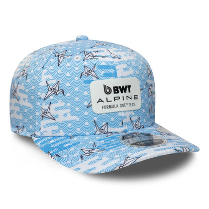 Alpine Racing Japan Race Special White New Era 9SEVENTY Stretch Snap Adjustable Cap, three-quarter view showing the BWT Alpine Formula One Team patch on the front panel with a blue wave and crane pattern, and 9SEVENTY size sticker on the visor.
