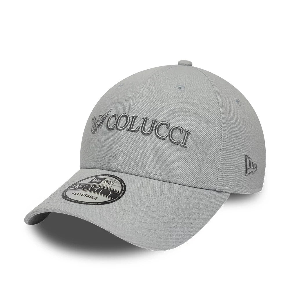 Colucci X New Era Grey 9FORTY Adjustable Cap, three-quarter view showing raised grey Colucci embroidery on the front panel, a pre-curved visor with a 9FORTY size sticker, and the New Era flag logo on the left side.