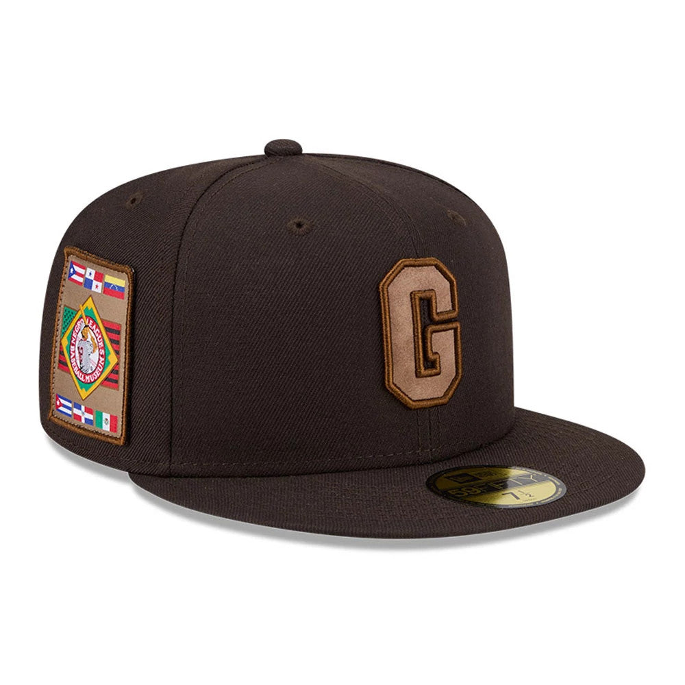 Homestead Grays MLB Negro League Dark Brown New Era 59FIFTY Fitted Cap, three-quarter view showing the brown embroidered G on the front panel, colourful patch on the right side, and a gold 59FIFTY size sticker on the flat visor.