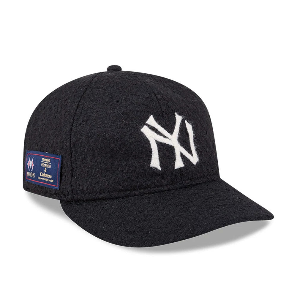 New York Yankees MLB X Moon Navy Retro Crown New Era 9FIFTY Adjustable Cap, three-quarter view showing the white raised-embroidered NY logo on the front panel, a navy visor, and a merino, cashmere and lambswool fabric label on the left side.