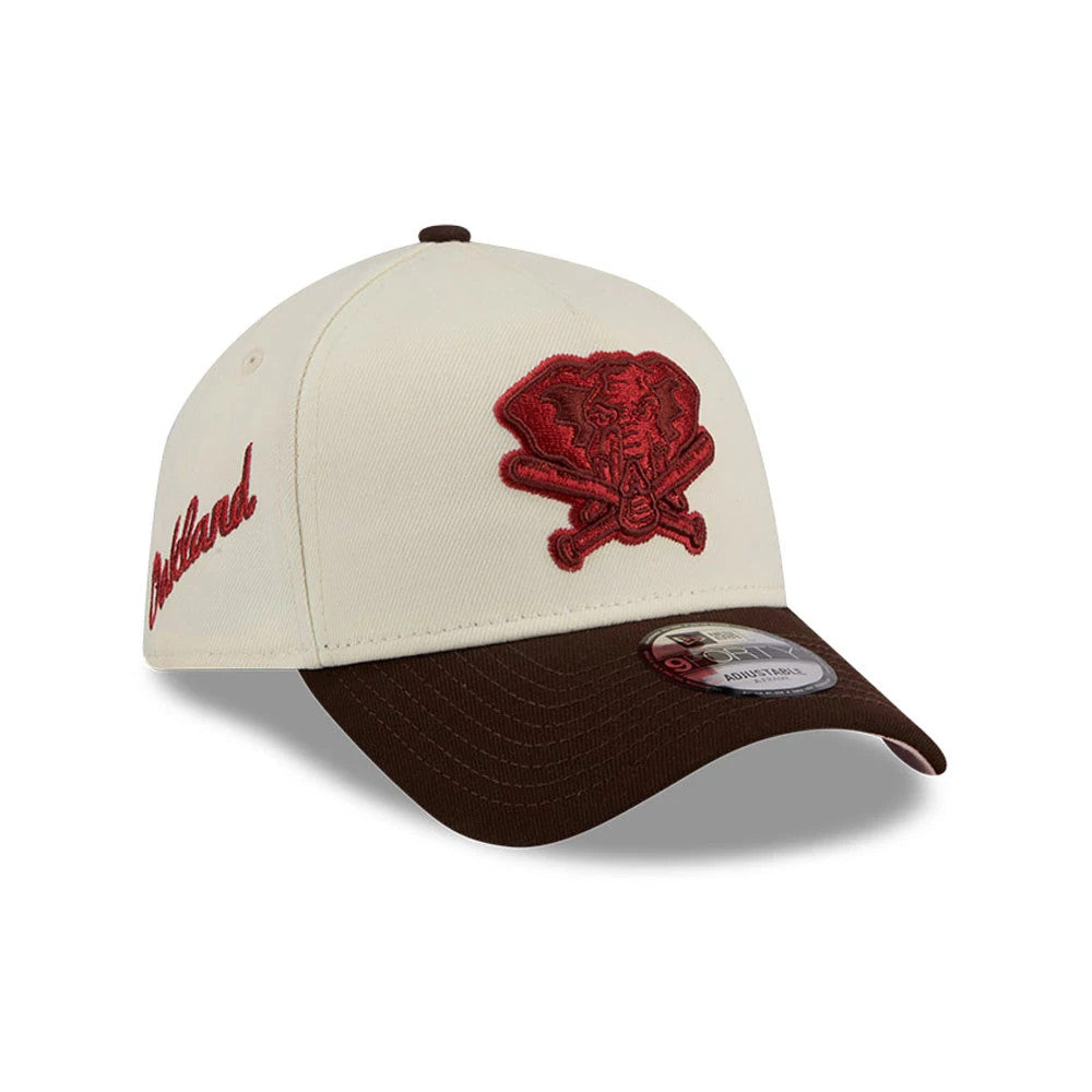 Athletics MLB City Script Cream New Era 9FORTY A-Frame Adjustable Cap, three-quarter view showing a large red embroidered logo on the front panel, brown curved visor with a 9FORTY size sticker, and script logo on the side.