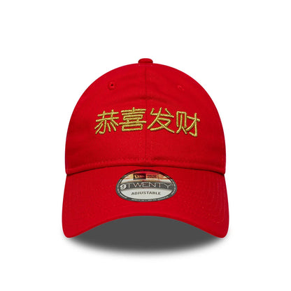 New Era Lunar New Year Red 9TWENTY Adjustable Cap, front view showing gold embroidered Chinese characters on the red crown, a curved visor, and a 9TWENTY size sticker centrally placed on the visor.