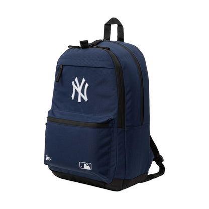 New Era New York Yankees MLB Navy Delaware Backpack, three-quarter view showcasing a spacious navy design with a prominent white embroidered Yankees logo on the front pocket, a black zip on the main compartment.