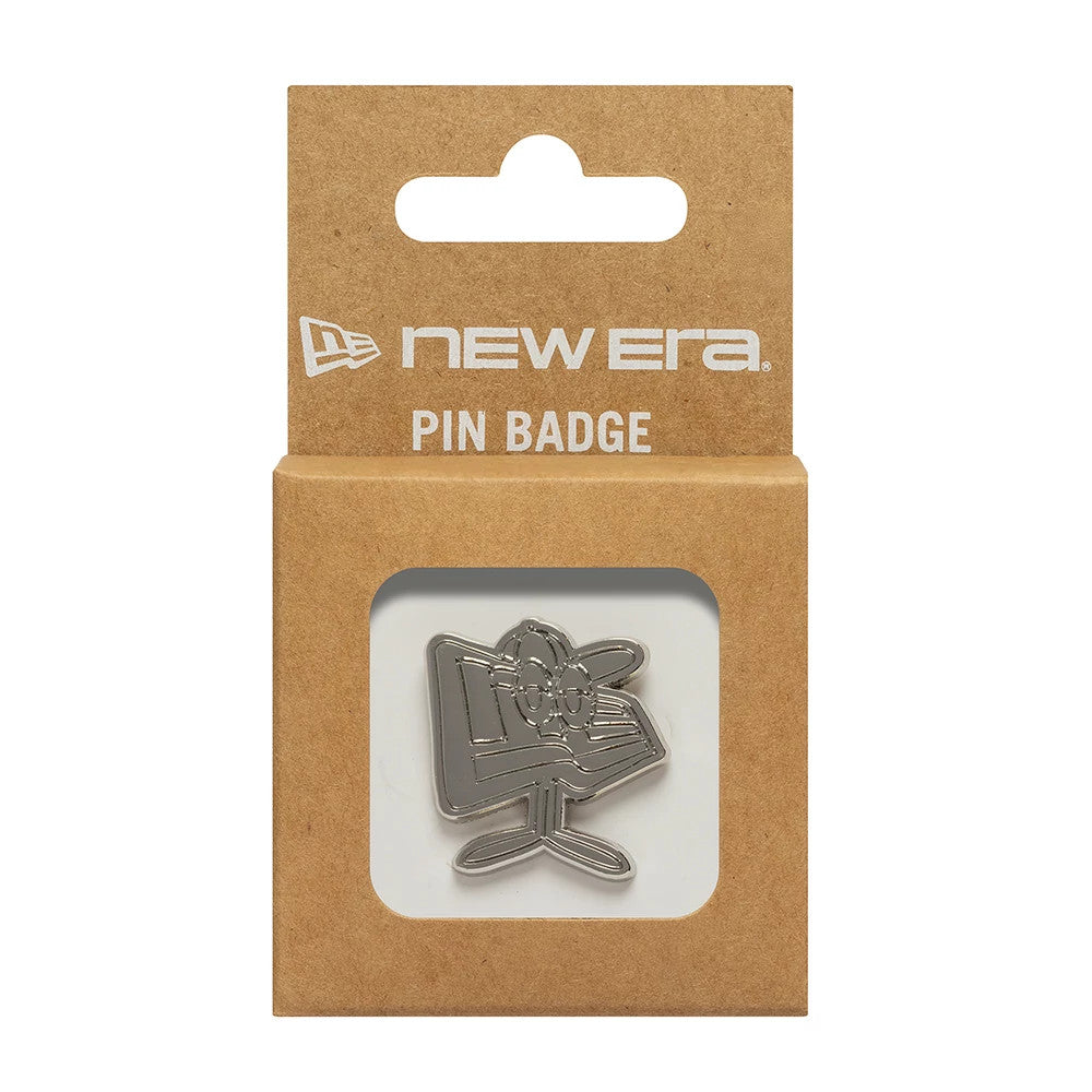 New Era Flag Character Silver Pin Badge, front view showing the pin with a raised character design in a silver finish, packaged in a natural brown card backing with a die-cut window, displaying the New Era printed logo above.