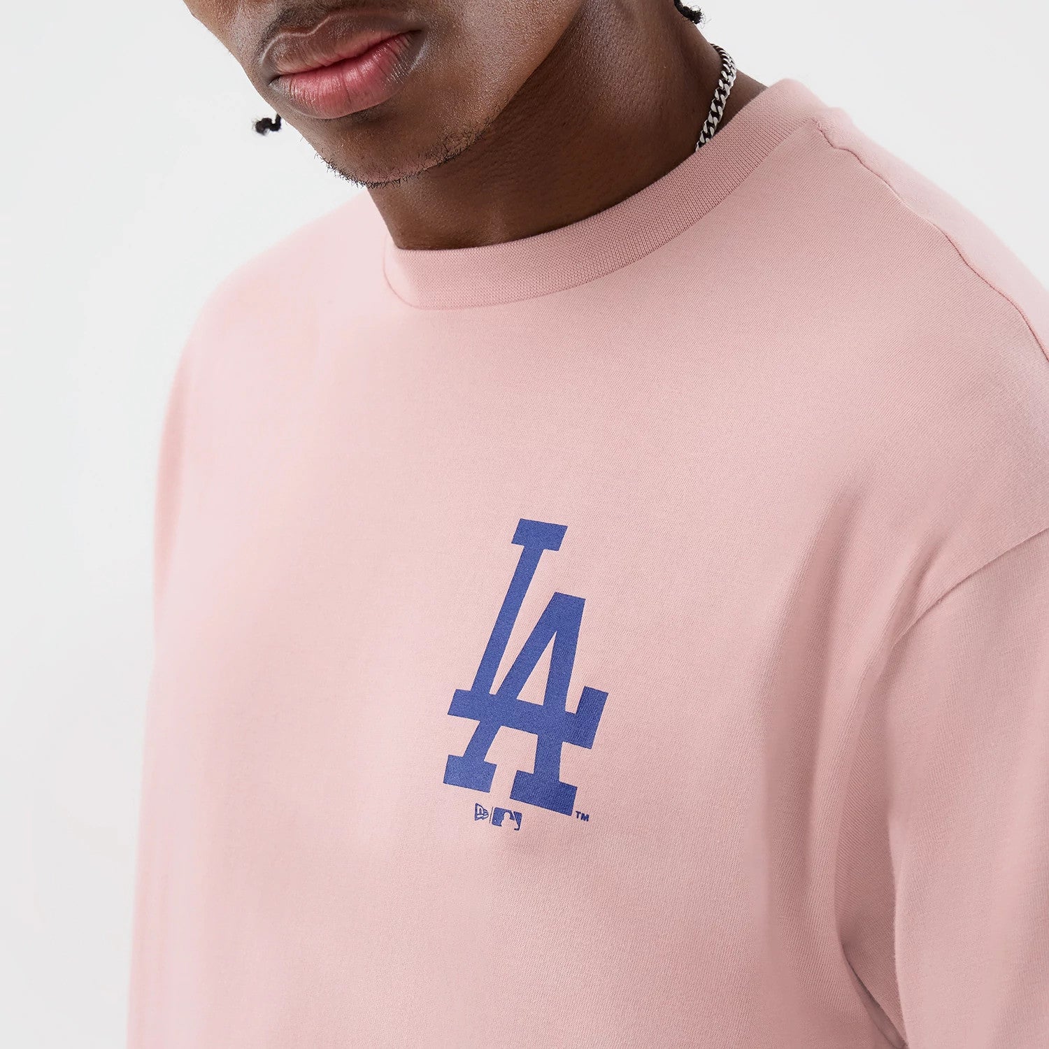 The model is wearing this MLB Cap Graphic LA Dodgers Oversized T-Shirt in pastel pink. 5