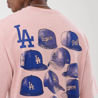 New Era LA Dodgers MLB Cap Graphic Pastel Pink Oversized T-Shirt, back view on a model showing multiple blue cap graphics featuring LA and Dodgers logos, with a large LA logo above, all set against the pastel pink fabric.