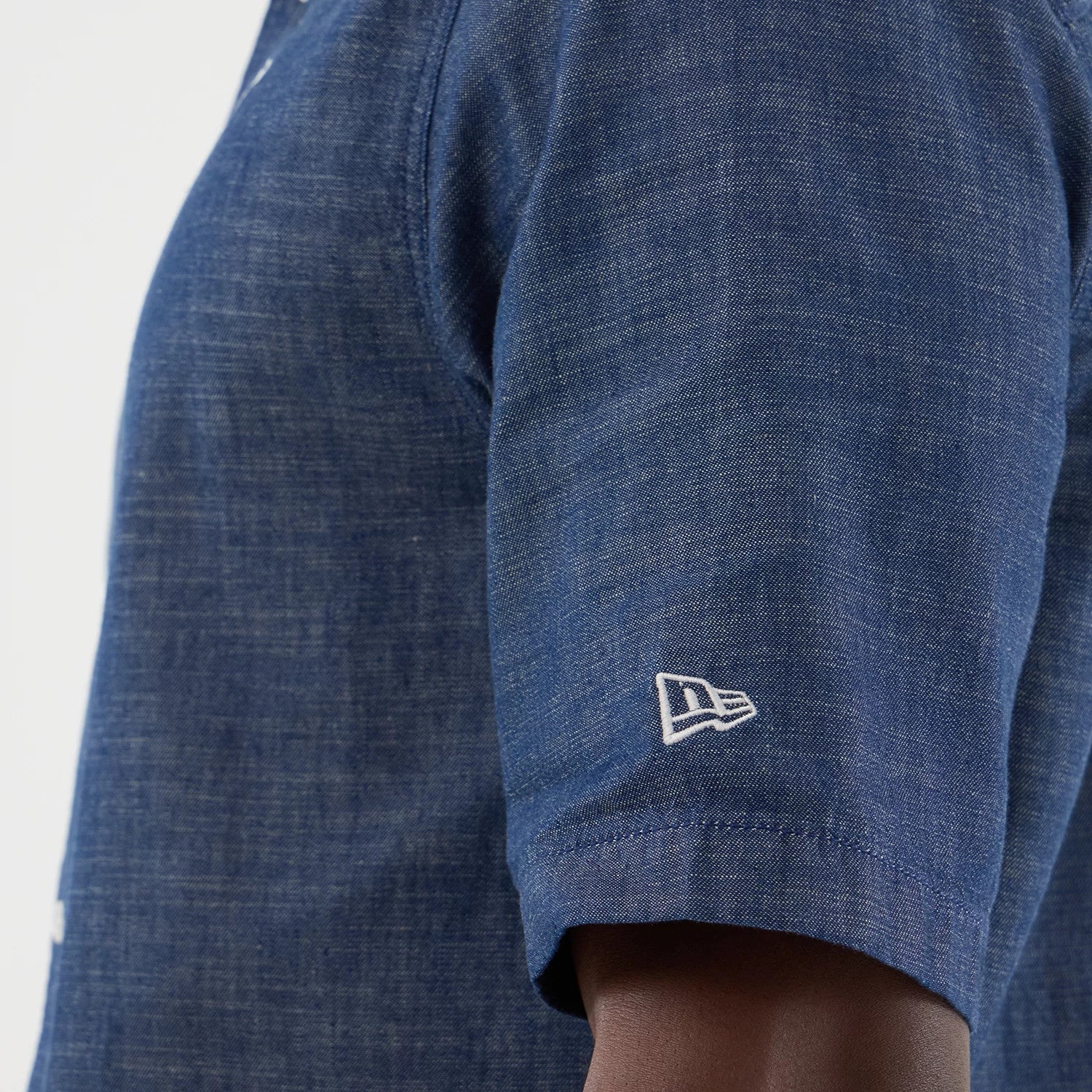 The model is wearing this New Era Denim Short Sleeve Shirt in blue. 5