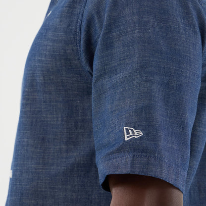 The model is wearing this New Era Denim Short Sleeve Shirt in blue. 5