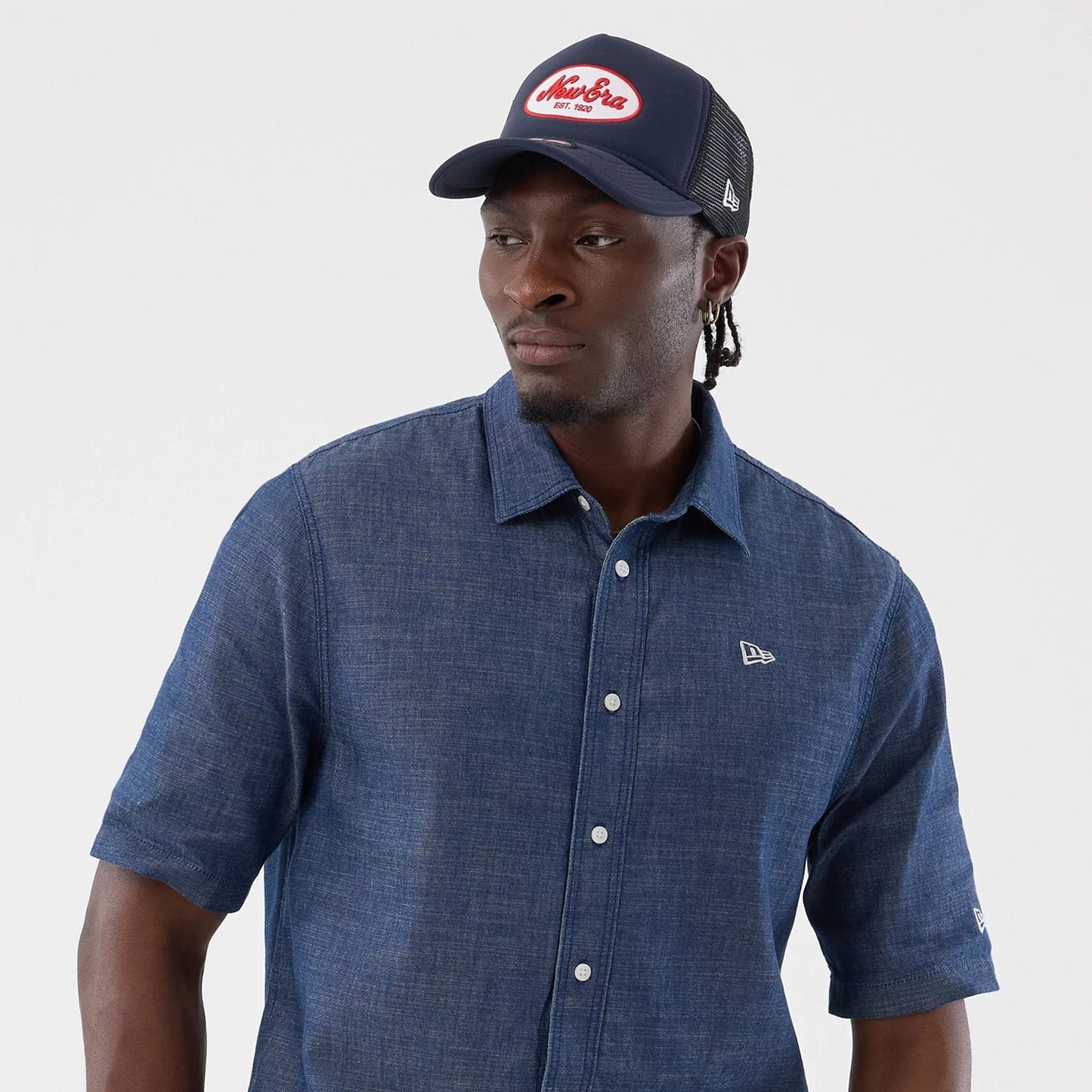 The model is wearing this New Era Denim Short Sleeve Shirt in blue. 6