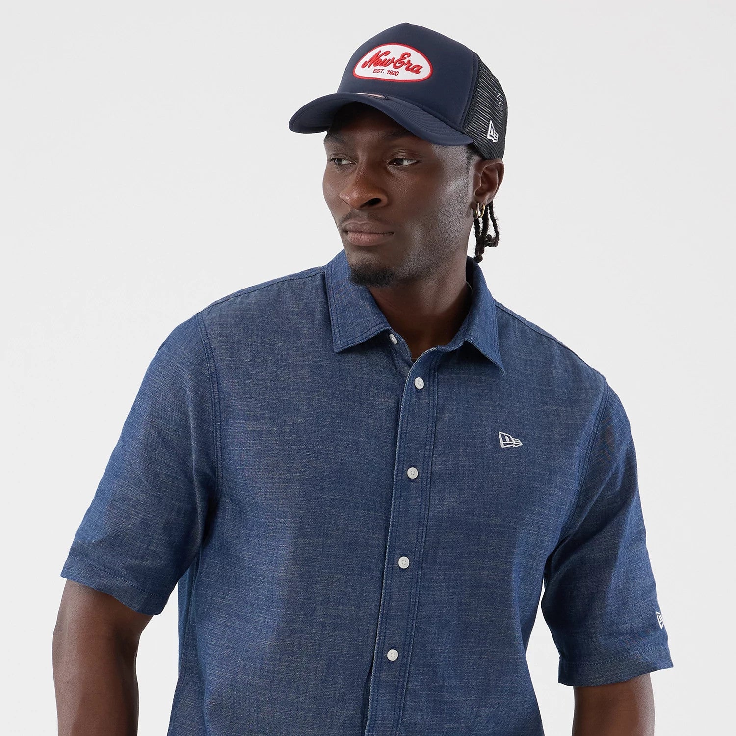The model is wearing this New Era Denim Short Sleeve Shirt in blue. 6