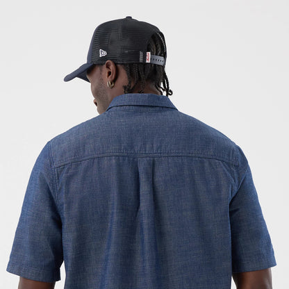 The model is wearing this New Era Denim Short Sleeve Shirt in blue. 7