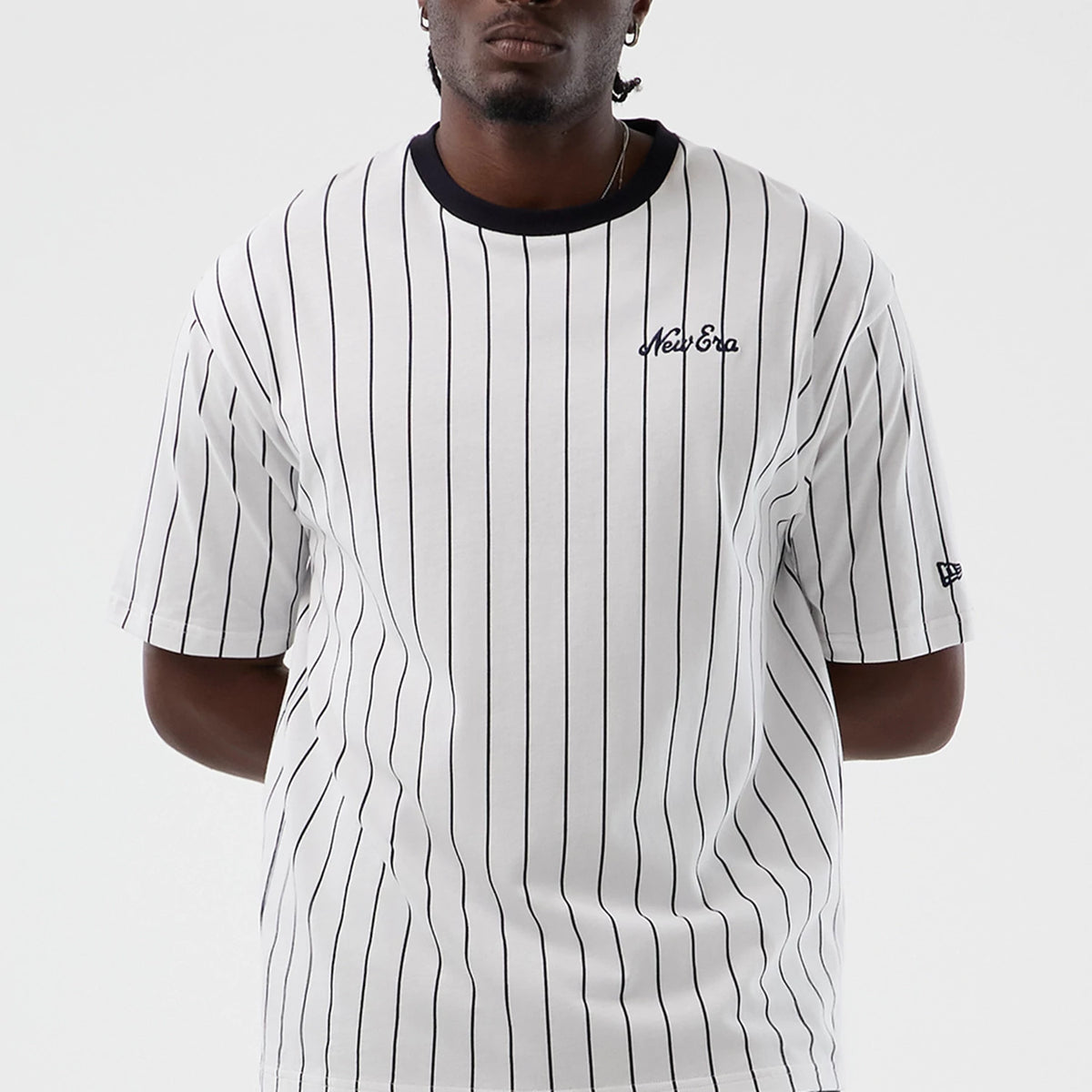 The model is wearing this New Era Pinstripe Oversized T-Shirt in Open White. 4