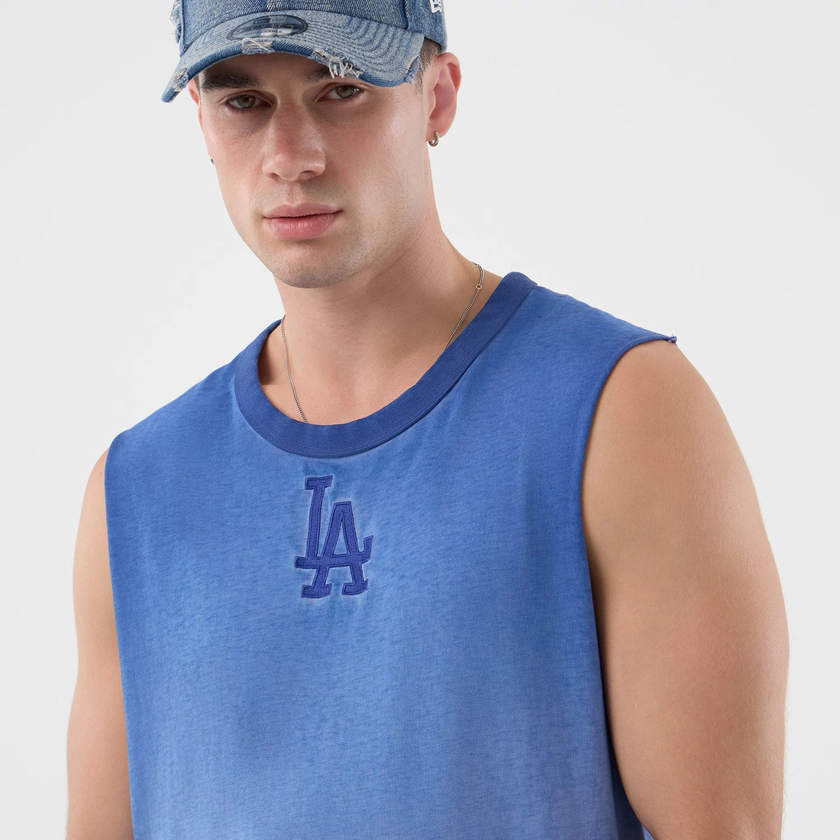 New Era LA Dodgers MLB Washed Logo Pastel Blue Vest, front view on a model with a matching denim cap, featuring a prominent embroidered LA logo in blue on the chest and a classic sleeveless design.
