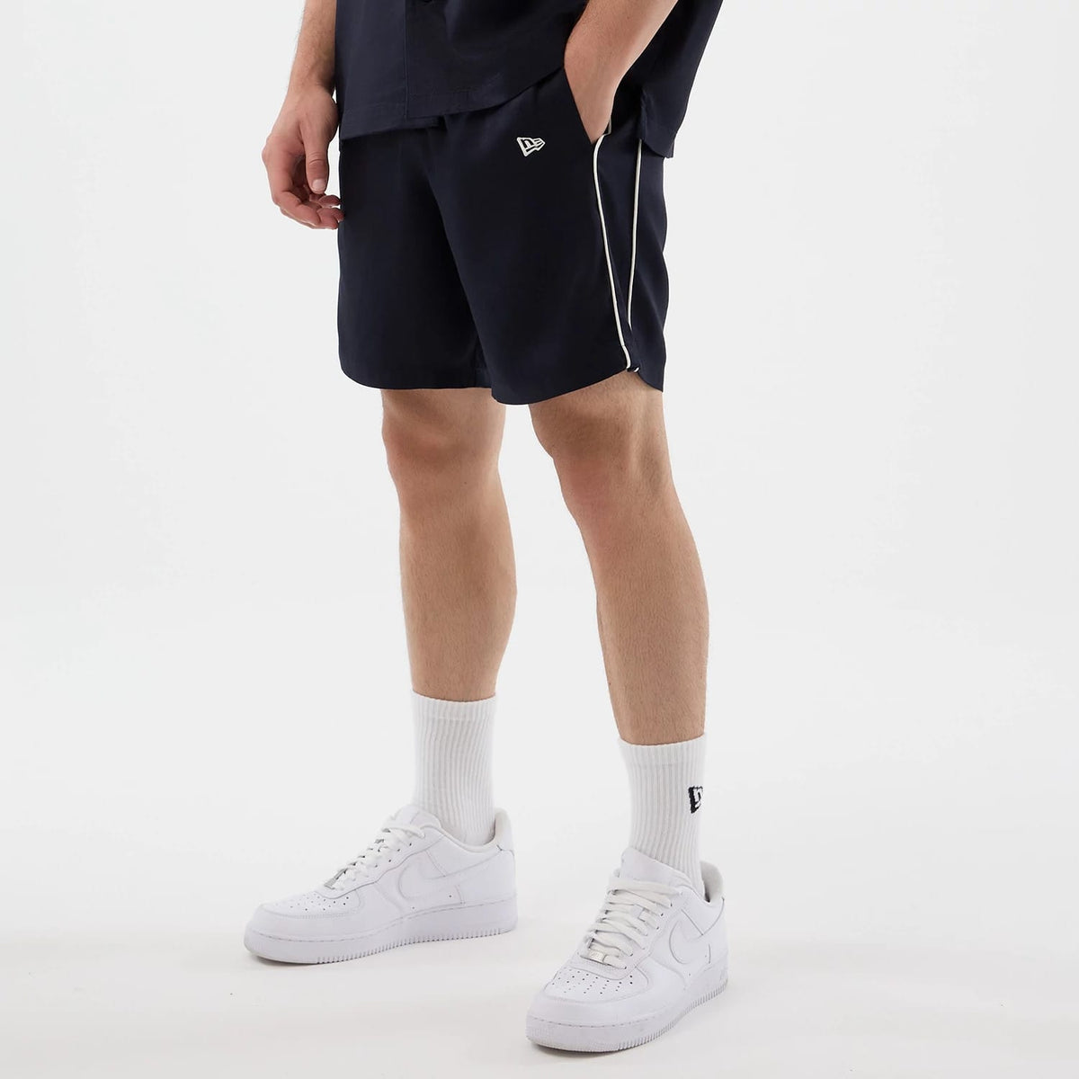 The model is wearing this New Era Piping Shorts in navy. 3