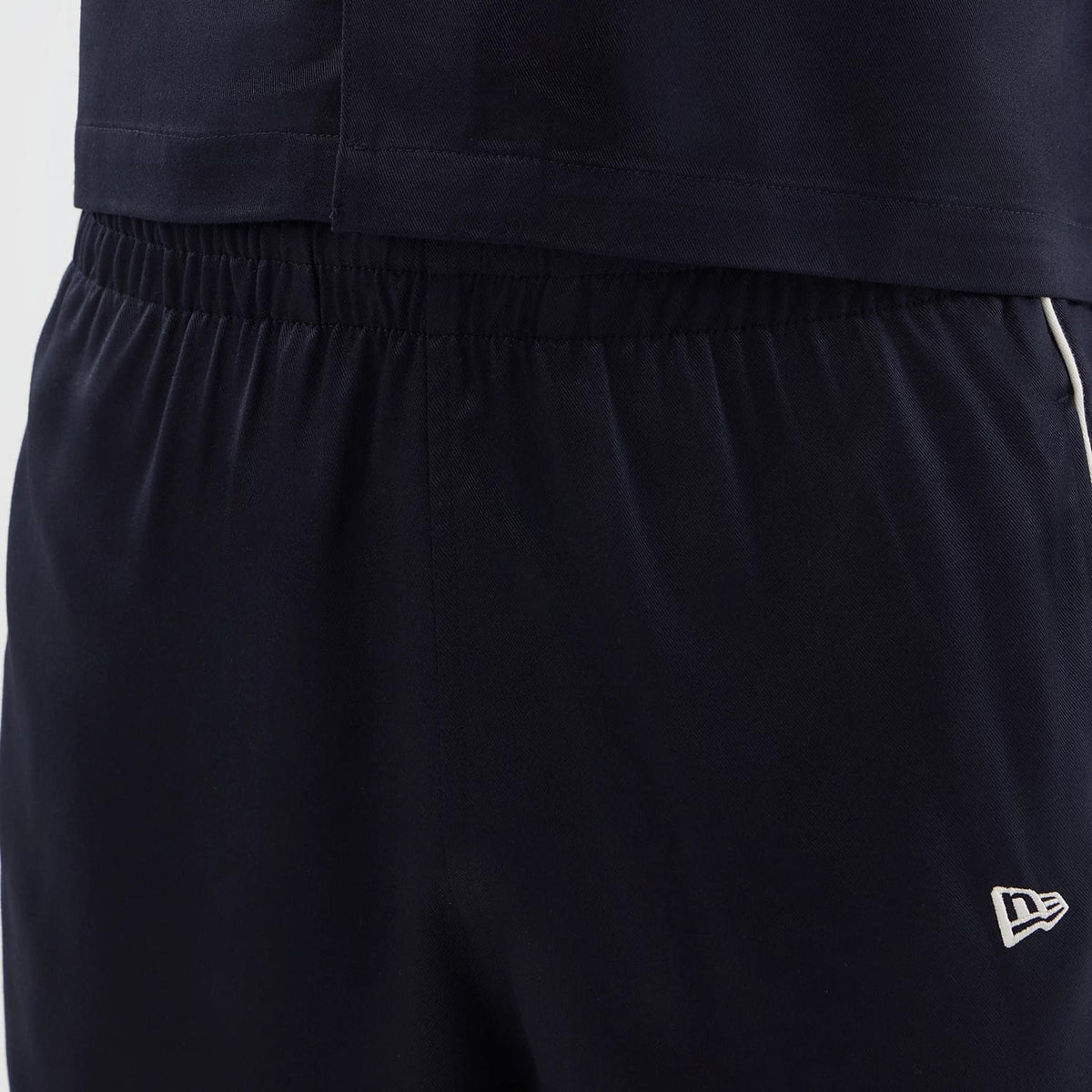 The model is wearing this New Era Piping Shorts in navy. 5