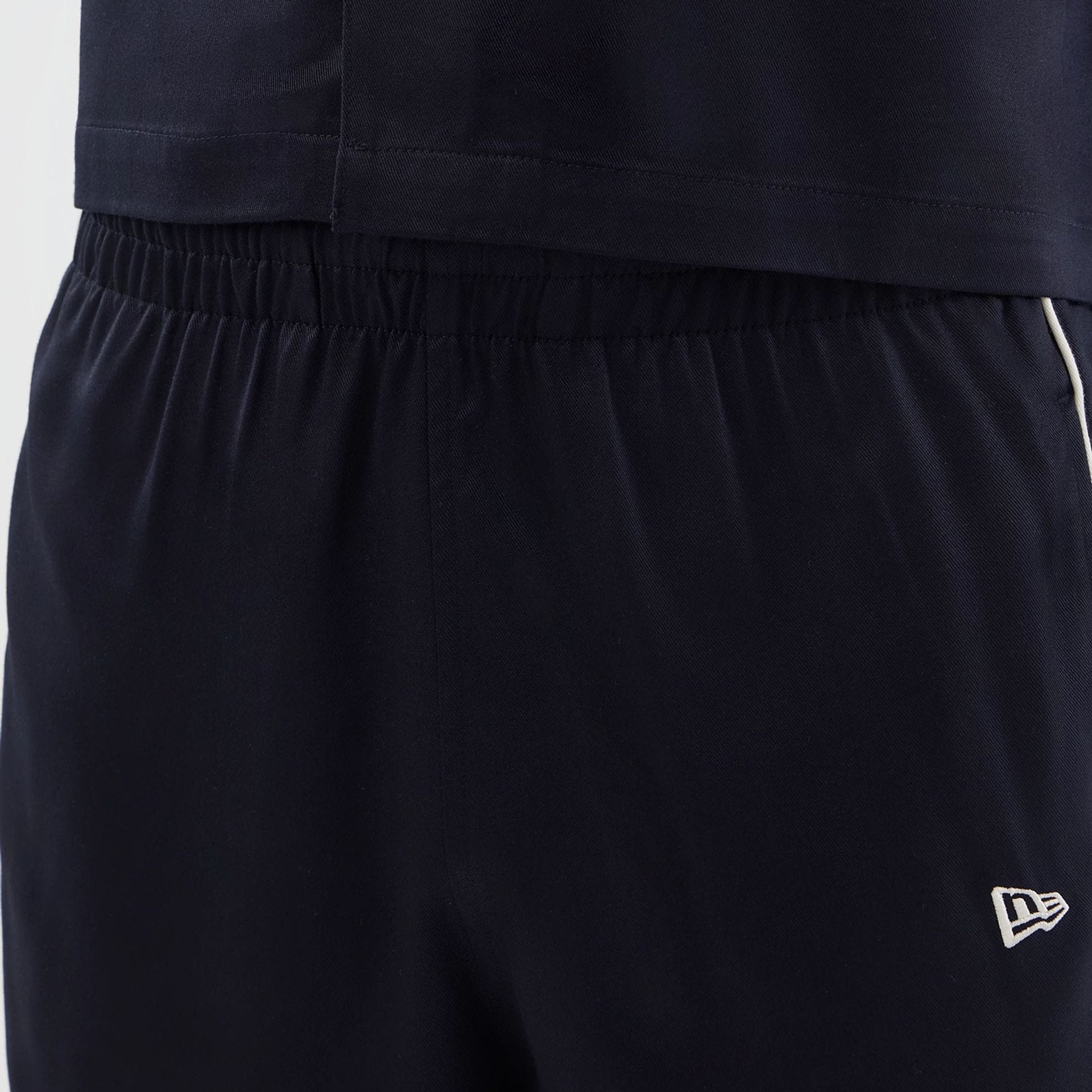 The model is wearing this New Era Piping Shorts in navy. 5