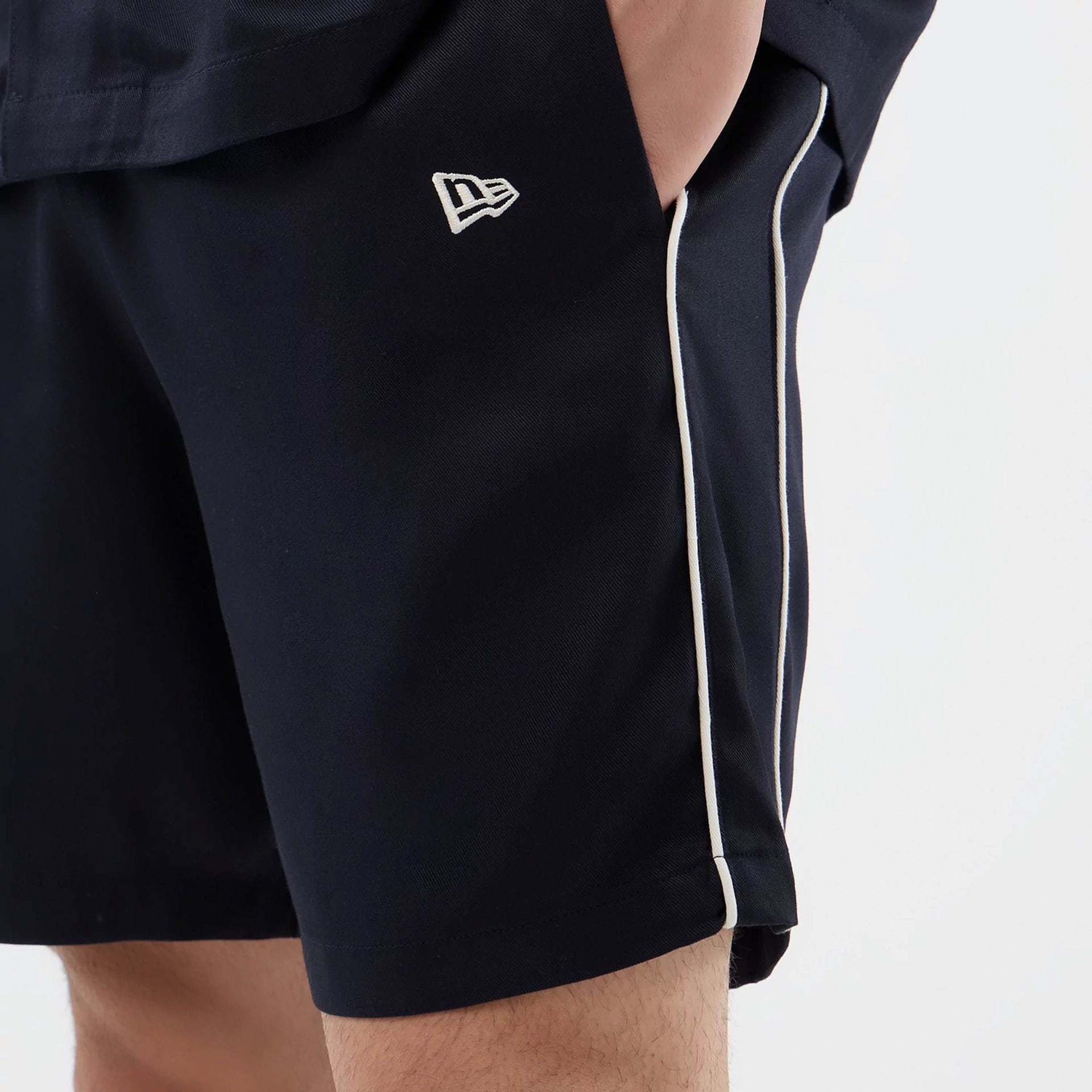 The model is wearing this New Era Piping Shorts in navy. 4