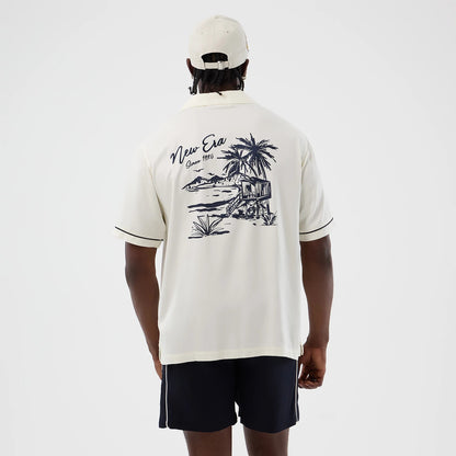 The model is wearing this New Era Graphic Revere Short Sleeve Shirt in open white. 2