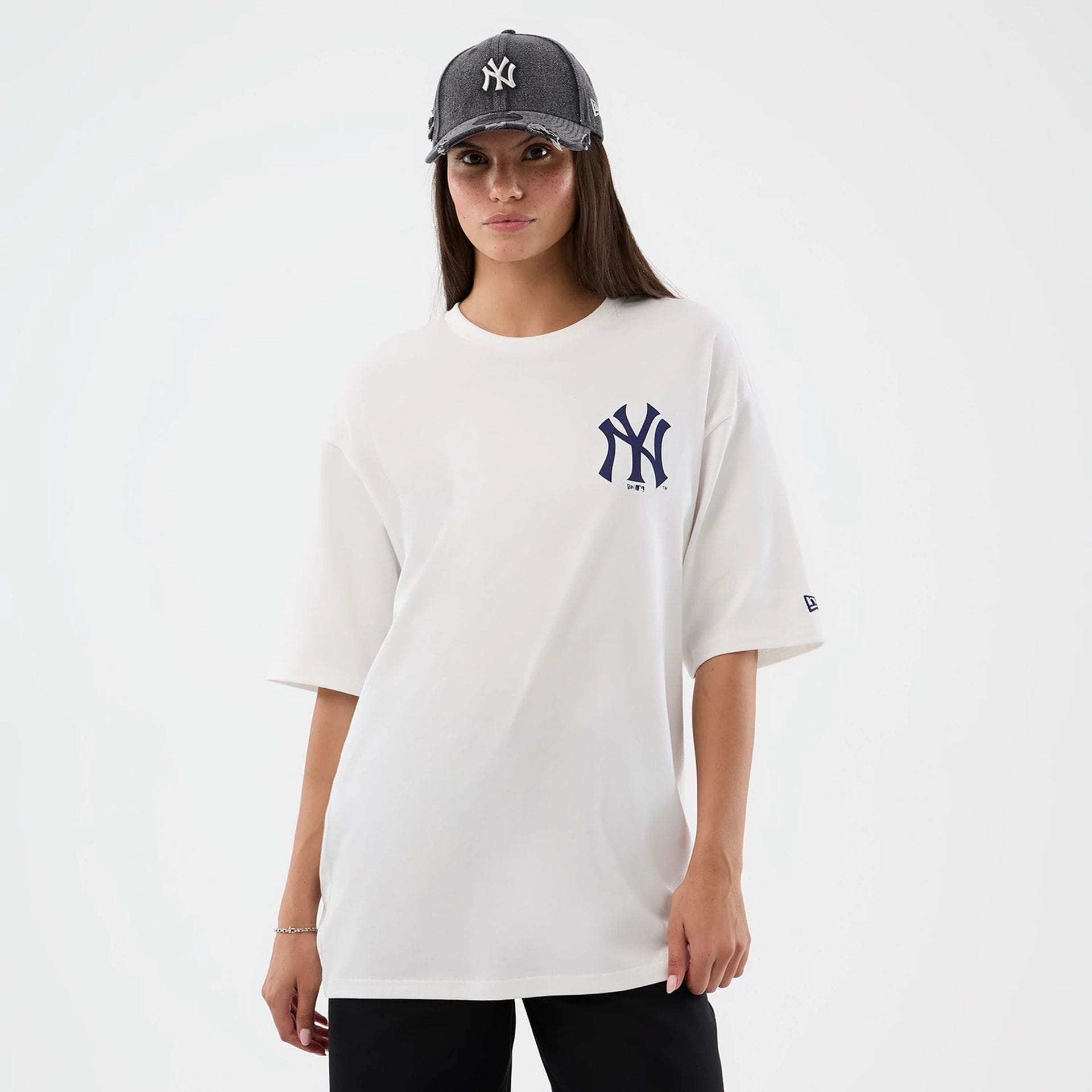 The model is wearing this MLB Cap Graphic New York Yankees Oversized T-Shirt in white. 5