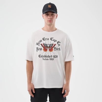 The model is wearing this New Era Death Moth Graphic Oversized T-Shirt in white. 1