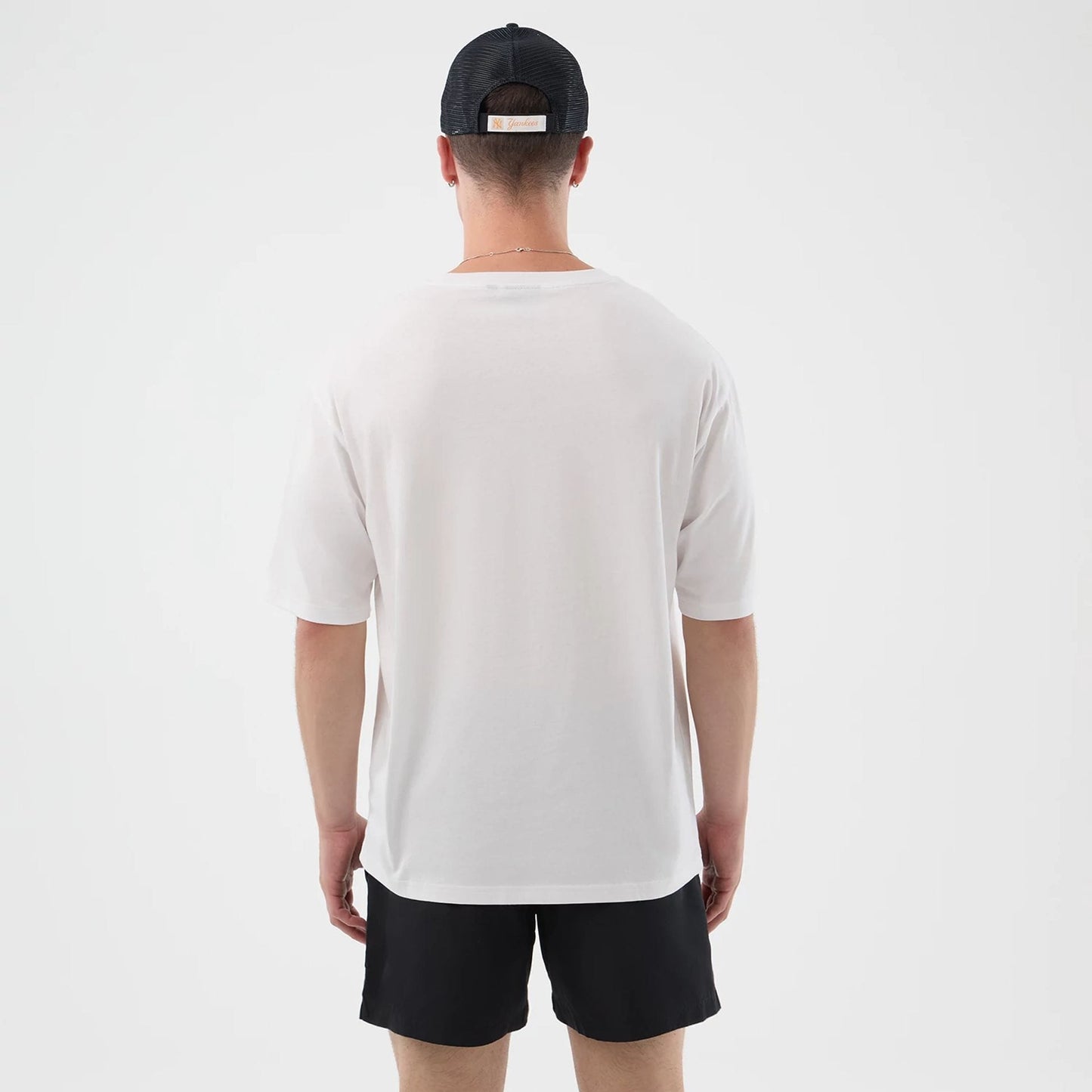 The model is wearing this New Era Death Moth Graphic Oversized T-Shirt in white. 2