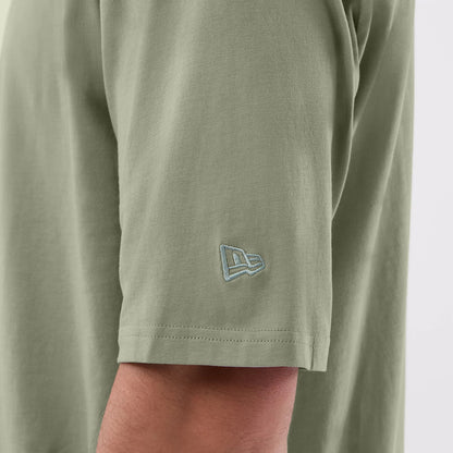 New Era Chicago Bulls NBA League Essential Pastel Green Oversized T-Shirt, side view showing a close-up of the short sleeve with an embroidered New Era logo in light blue near the hem.