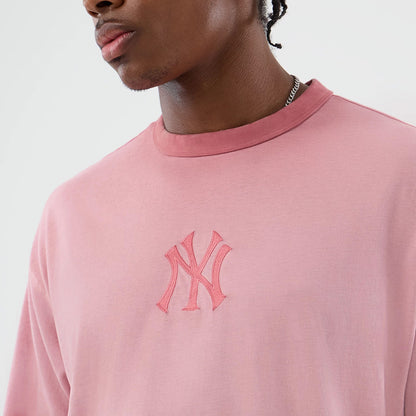 New Era New York Yankees MLB Washed Logo Pastel Pink T-Shirt, front view on-model highlighting the embroidered New York Yankees logo across the chest, with a round neckline and relaxed fit in a soft pastel pink hue.