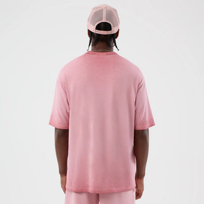New Era New York Yankees MLB Washed Logo Pastel Pink T-Shirt, back view on a model with a matching pastel pink cap, showcasing a plain design with a relaxed fit, short sleeves, and a round neckline, accentuating the shirt's soft pink hue.