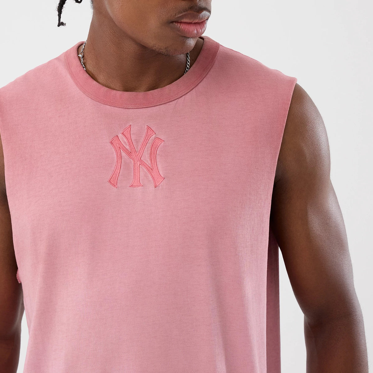 New Era New York Yankees MLB Washed Logo Pastel Pink Vest, front view on a model showing a sleeveless design with a ribbed crew neckline, featuring the raised embroidery of the NY logo on the chest for a athletic appearance.