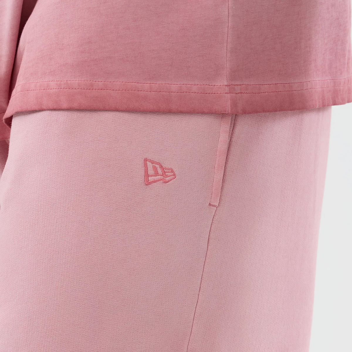 New Era New York Yankees MLB Washed Logo Pastel Pink Shorts, side view highlighting the soft pastel pink shade, a small embroidered New Era logo near the side seam, and the finished waistband at the top of the shorts.